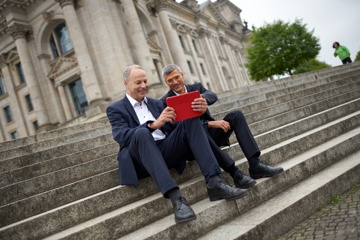 Zwei Mitarbeiter besprechen gemeinsam Inhalte auf einem Tablet