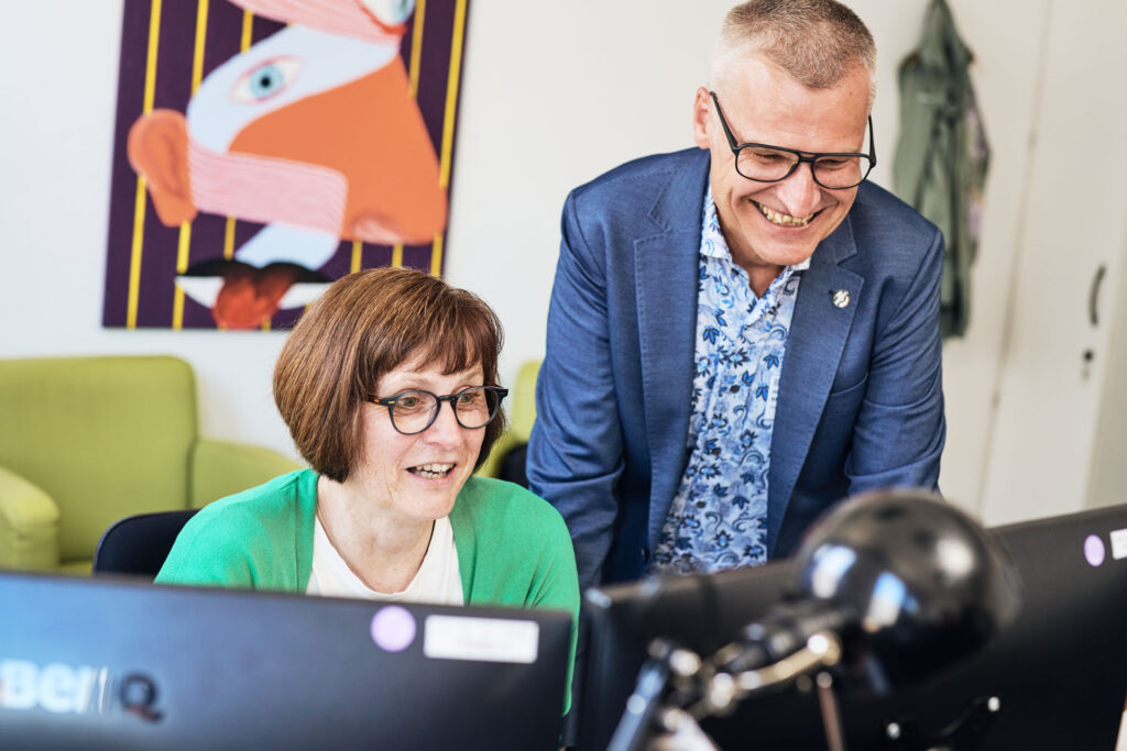 Zwei Mitarbeitende arbeiten gemeinsam an einer Website