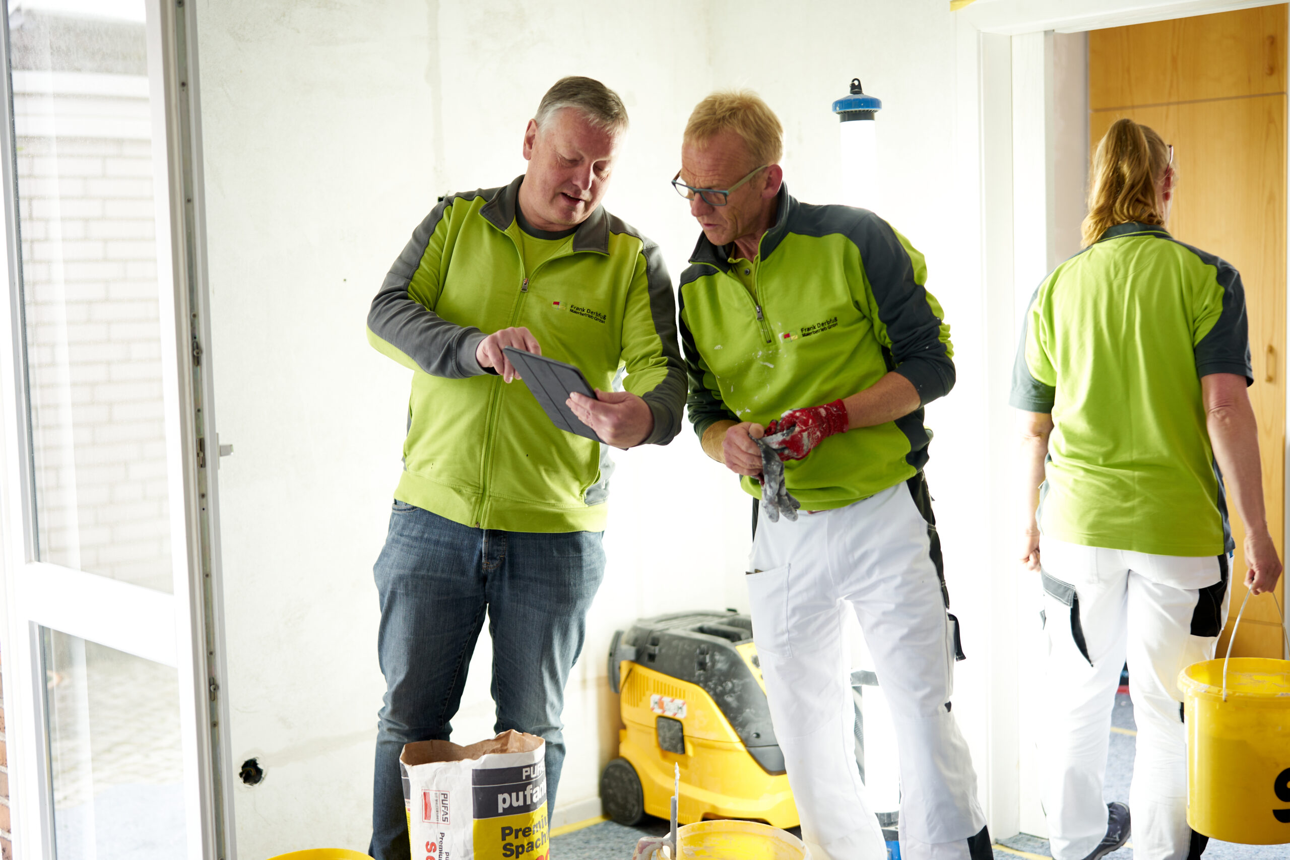 Industrie, Handwerk & Fahrzeugbau Baustelle Handwerker im Gespräch mit Ipad