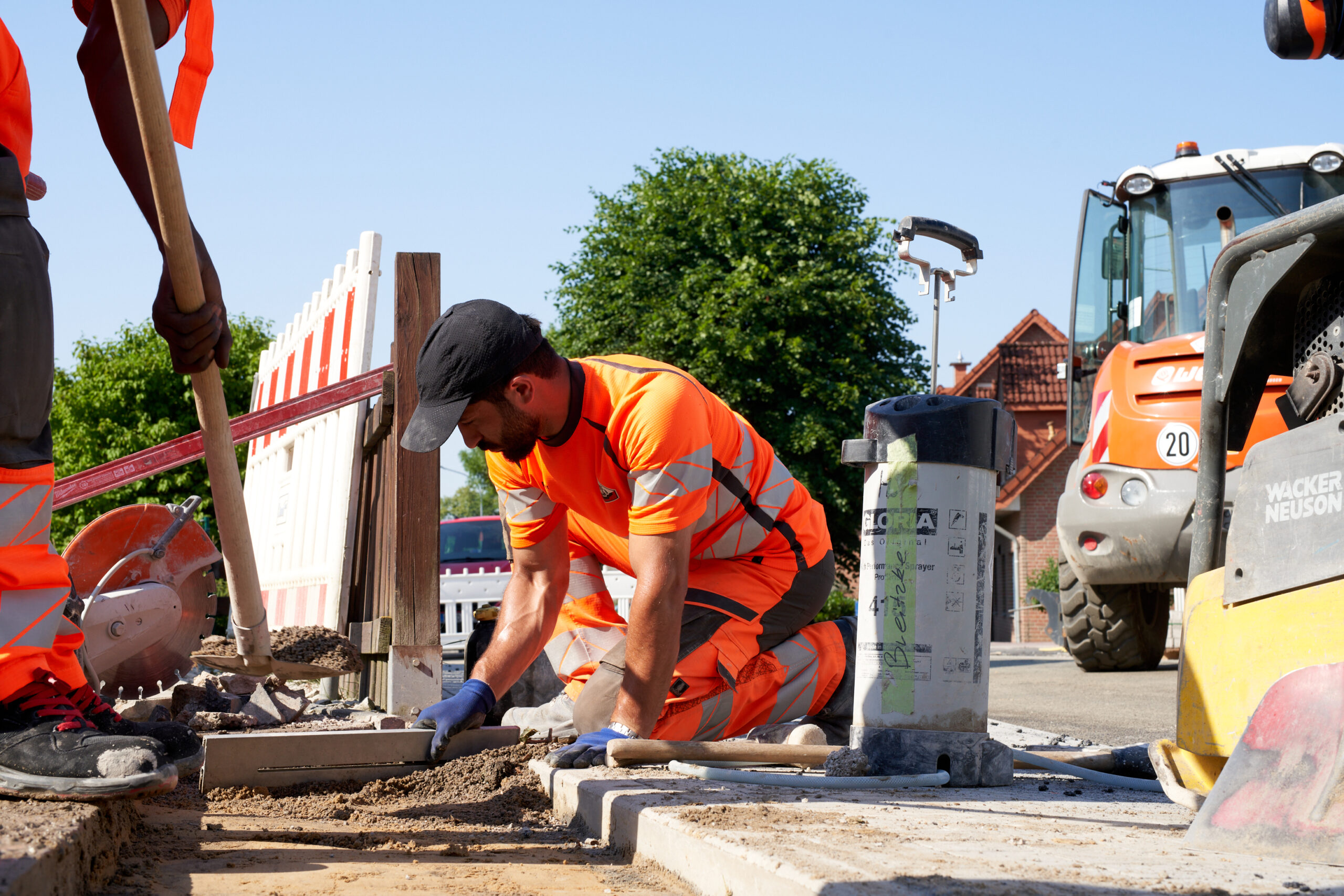Straßenbauer bei Pflaster- und Bordarbeiten auf einer Baustelle