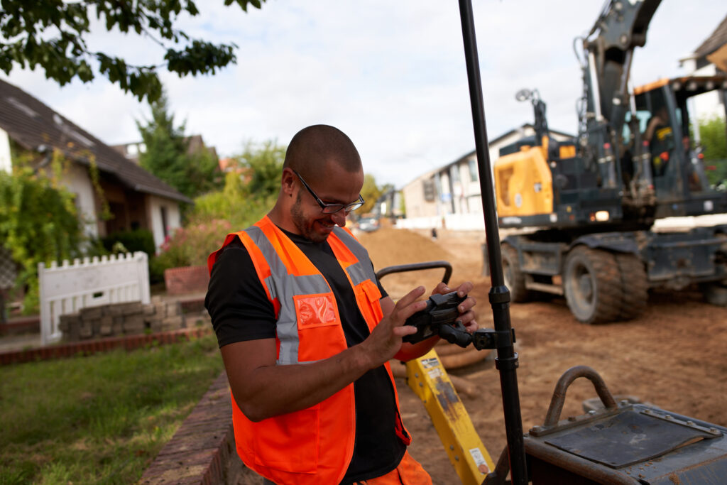Straßenbauer bei der digitalen Vermessung auf einer Baustelle